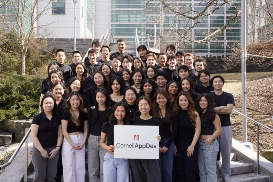 The Cornell AppDev team on the Gates Hall steps holding a CornellAppDev sign